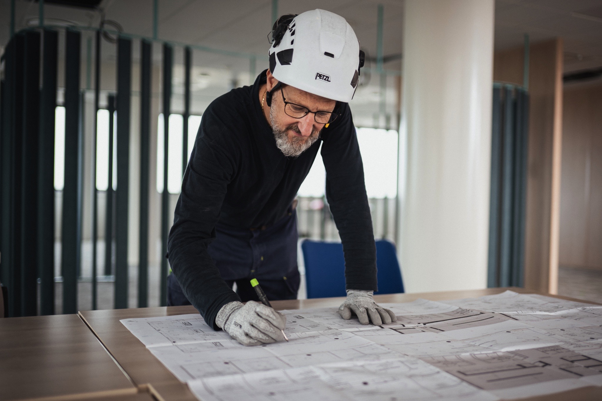 Technicien analysant des plans techniques afin de préparer une intervention d’installation ou de maintenance dans un bâtiment tertiaire.