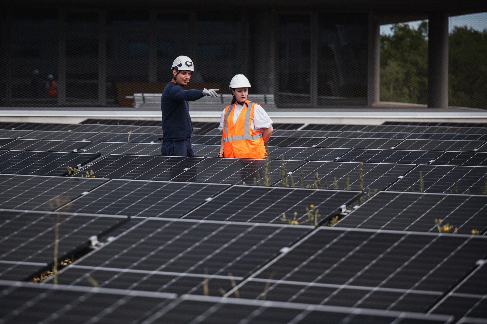 Techniciens intervenant sur une installation photovoltaïque en toiture composée de panneaux solaires destinés à la production d’électricité renouvelable.